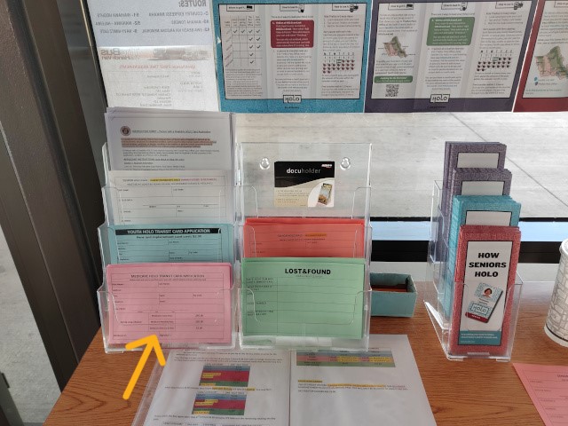 シニアHOLOカードのピンク色の申請用紙の置き場を、黄色の矢印で示した写真