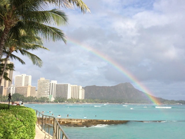 ダイヤモンドヘッドを望みハワイワイキキの海にかかる虹を撮影した写真