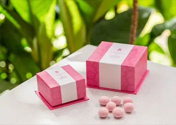 ロイヤルハワイアンベーカリーのキュートなピンクの箱に入った「ピンクマカダミアナッツ」の写真