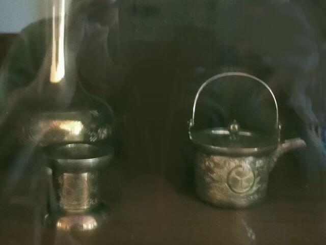 イオラニ宮殿地下ギャラリーの、徳川家から贈られた茶器セットの写真（葵の紋様あり）